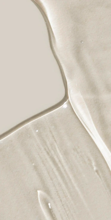 An abstract, high-key background texture featuring a smooth, milky white liquid surface with soft ripples and subtle shadows.