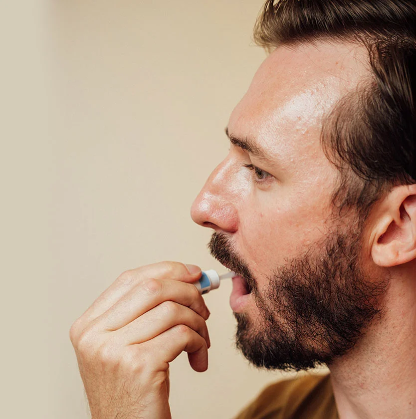 A male patient uses a specialized topical applicator for precise at-home hair treatment.
