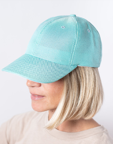 A woman in a white shirt shields her eyes from the sun, showcasing vibrant, healthy hair.